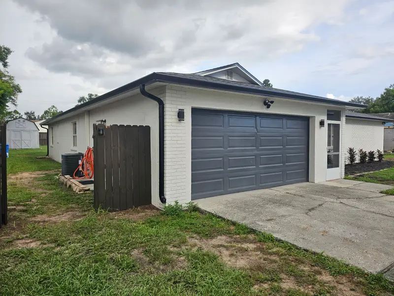 Customer photo: white ranch home with a charcoal garage door and a new dark shingle roof