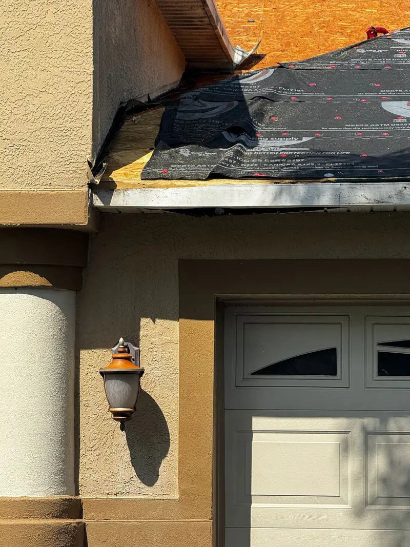 Underlayment run to the eave edge over a stucco soffit during a re-roof