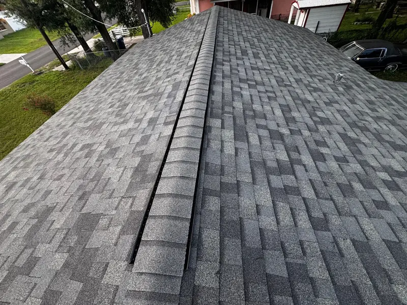 Close view of a new shingle ridge and ridge vent on a finished roof