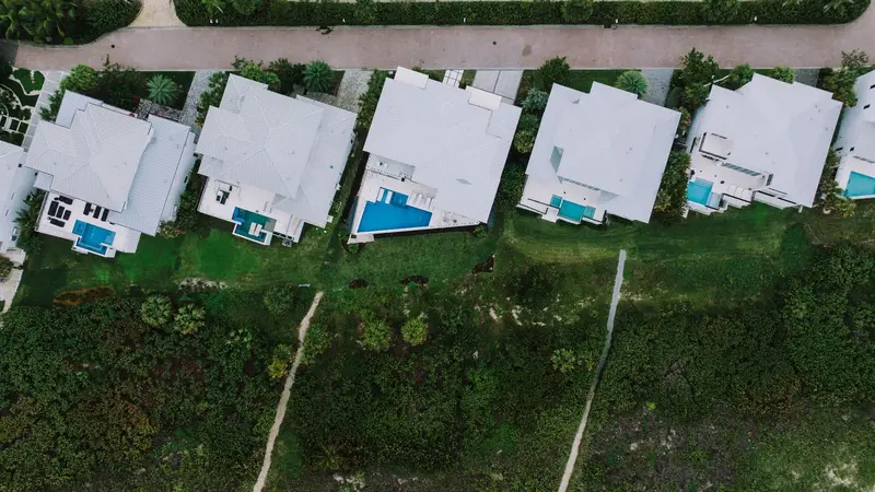 Aerial view of Florida homes with white low-slope roofs and pools