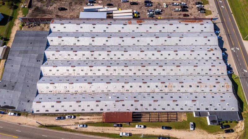 Aerial view of a long low-slope metal roof on a warehouse