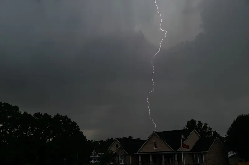 Lightning over a suburban house at dusk