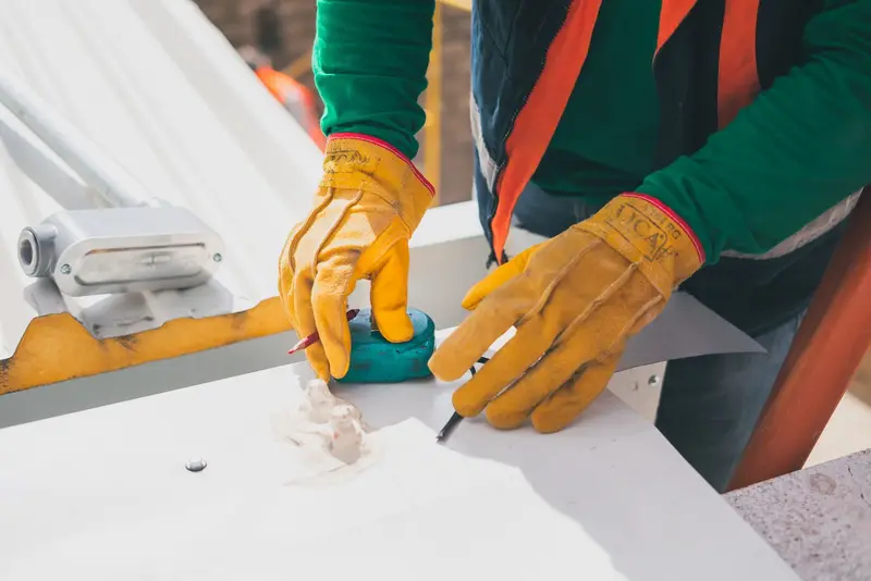 Gloved hands marking sheet metal flashing before it is cut