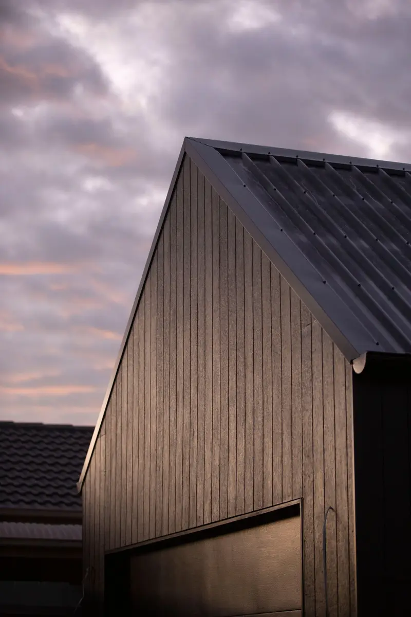 Black metal roof on a modern house at dusk