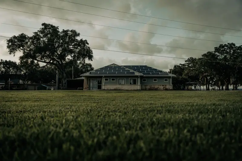 Florida home under live oaks with storm clouds building overhead